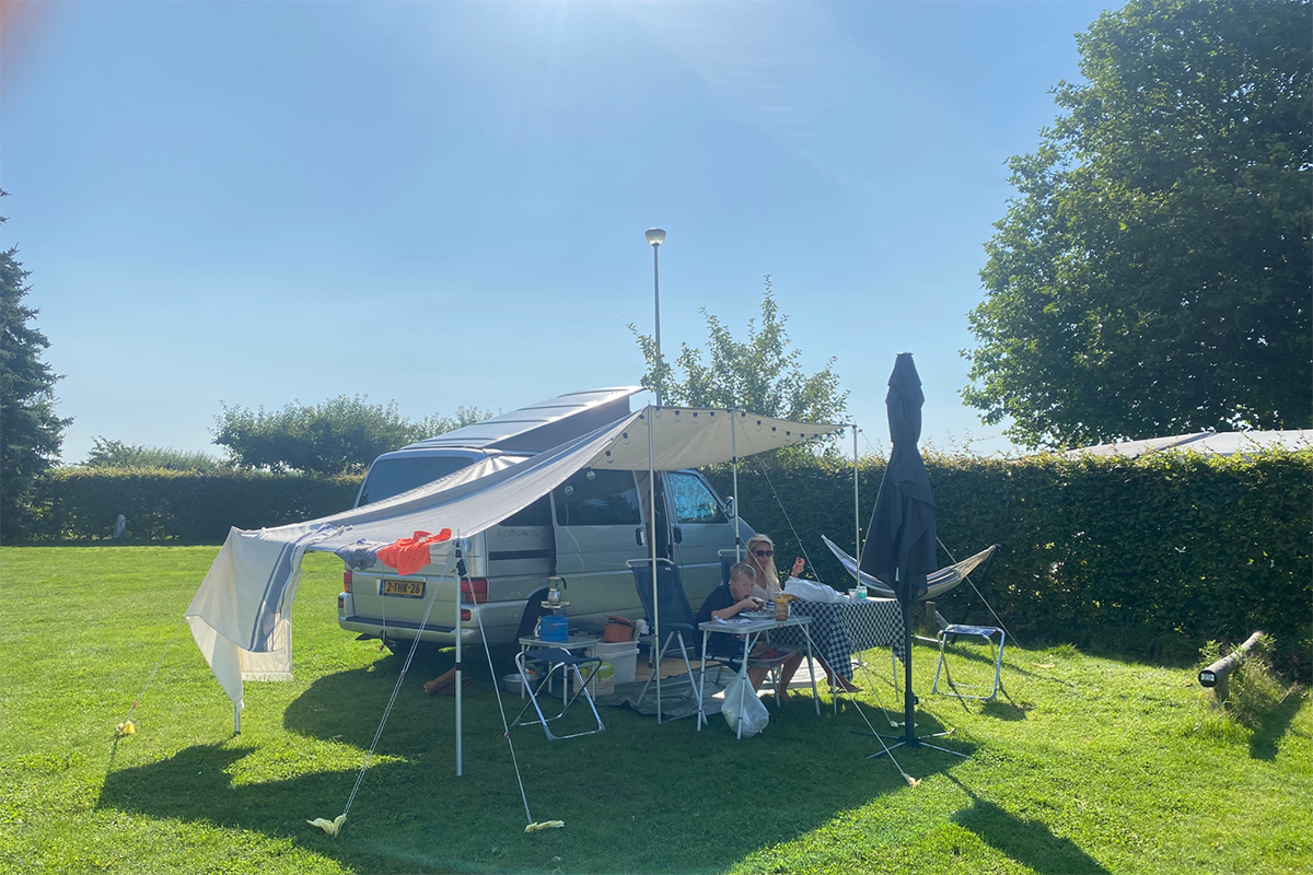 Moeder en zoon zitten gezellig voor camper