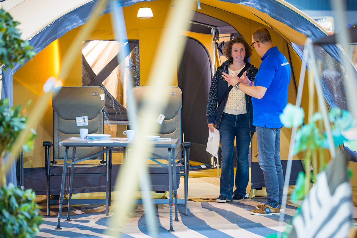 verkoper praat in tent met bezoeker