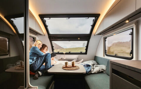 Camper interieur van Adria met 2 mensen zittend in de camper