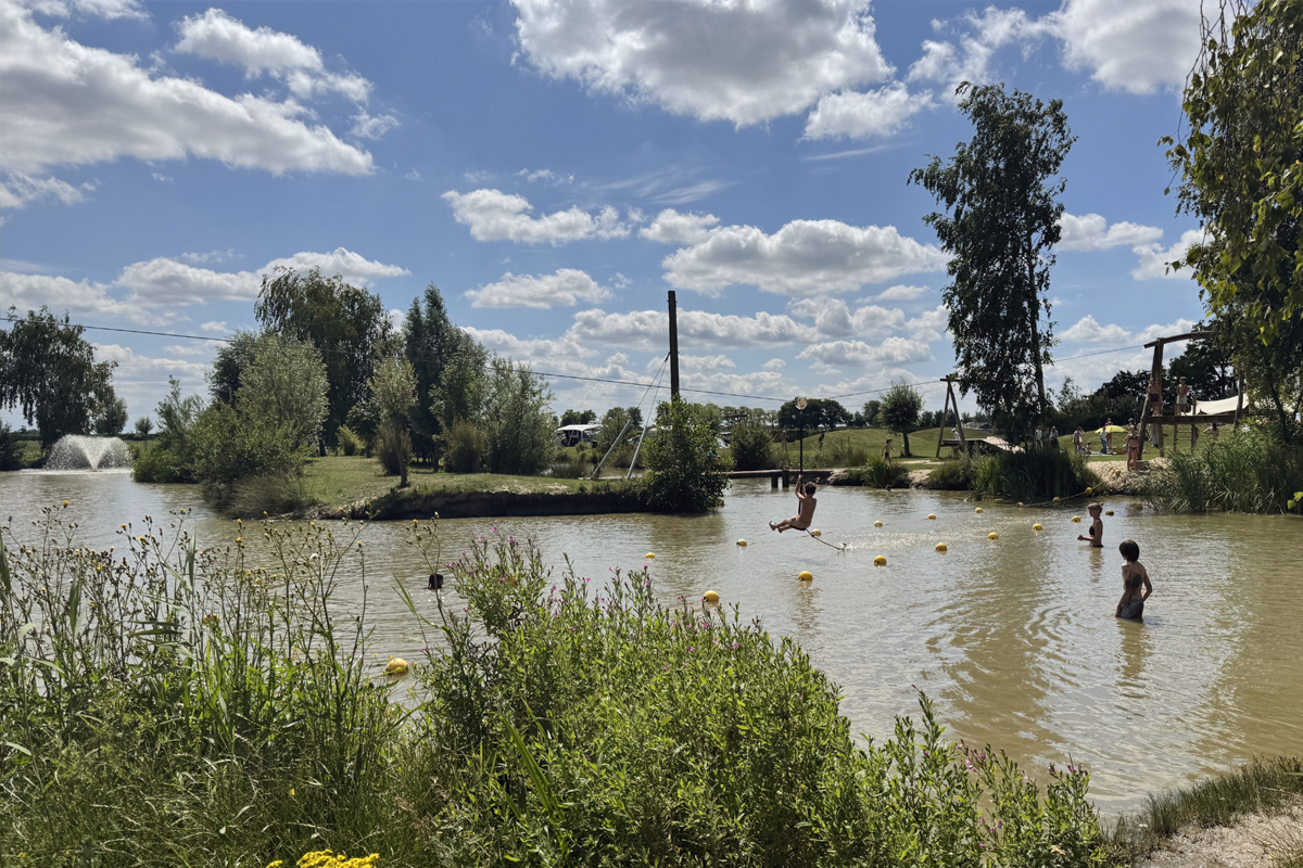 Kinderen spelen en zwemmen in de natuurlijke speelvijver van Buitengoed de Boomgaard