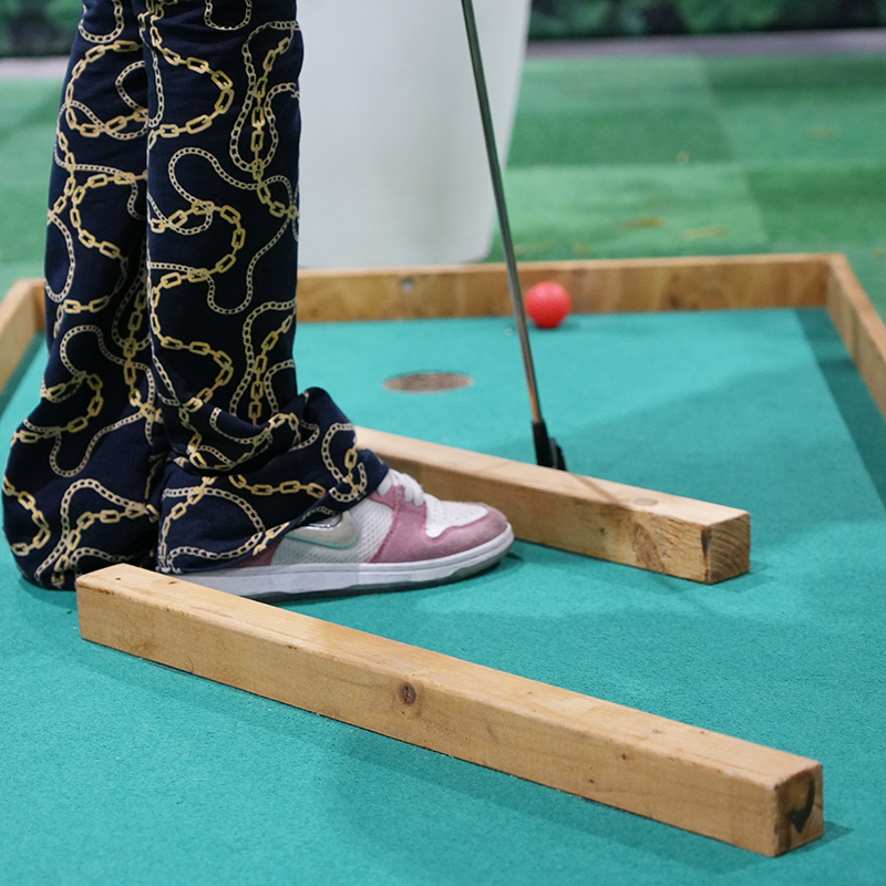 deatail van minigolf baan met persoon erop